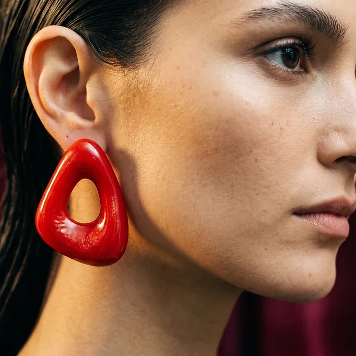 Campaign frame: red sculptural earring in profile